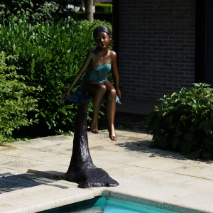 Bronzeskulptur "Mädchen sitzt auf Baumstamm"