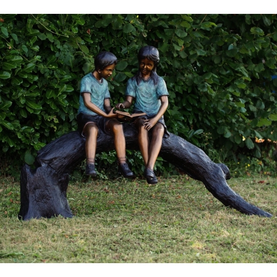 Bronzeskulptur "Junge und Mädchen auf Baumstamm"